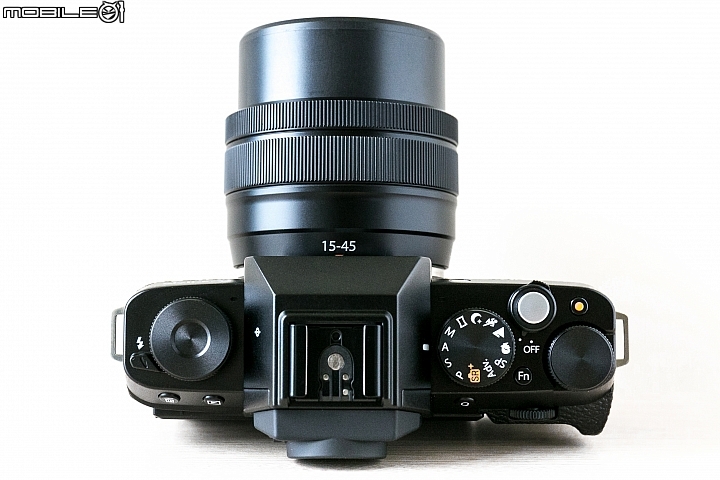 Fujifilm X-T100-機頂的部分,左肩設有功能轉盤及閃燈開啟撥感,中間是熱靴座與隱藏的內閃,右肩則有曝光模式轉盤、快門鍵/電源鍵、錄影鍵、Fn快捷鍵與一具指令轉盤。 Fujifilm X-T100-機頂的部分,左肩設有功能轉盤及閃燈開啟撥感,中間是熱靴座與隱藏的內閃,右肩則有曝光模式轉盤、快門鍵/電源鍵、錄影鍵、Fn快捷鍵與一具指令轉盤。