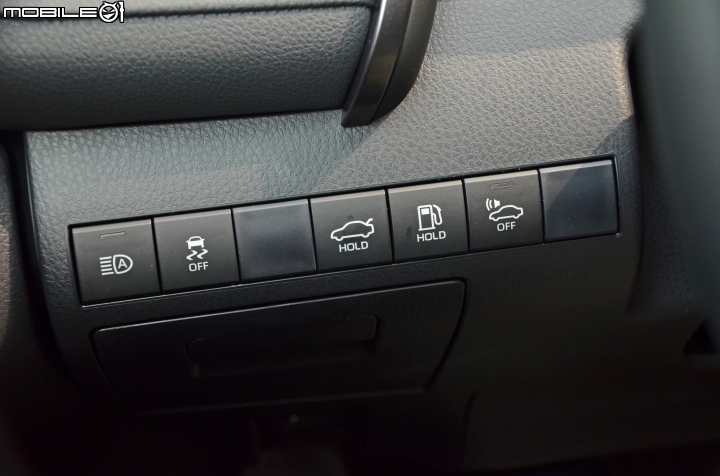 Toyota New Camry Hybrid,方向盤後方靠近車門的位置,可見一排按鍵,包括:自動遠光燈、車身穩定系統、行李廂蓋、油箱蓋與車輛接近行人警示系統。 Toyota New Camry Hybrid,方向盤後方靠近車門的位置,可見一排按鍵,包括:自動遠光燈、車身穩定系統、行李廂蓋、油箱蓋與車輛接近行人警示系統。