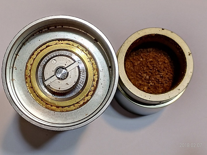請問咖啡粉為何會沾附在手磨出粉口(有附圖)