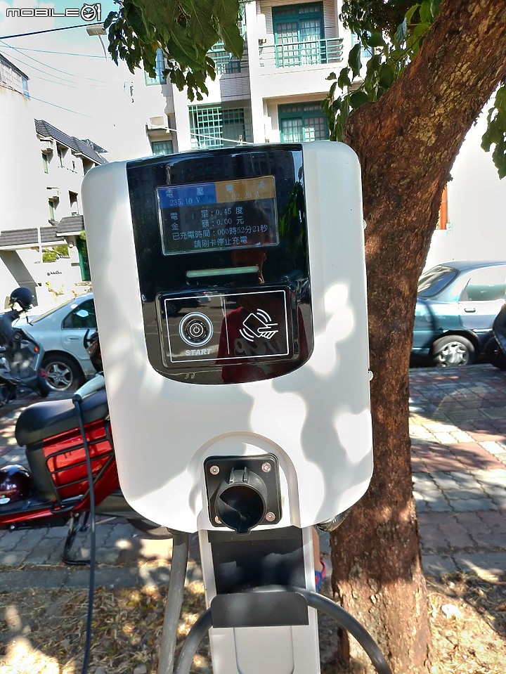 沒看過的電動機車，掛「試車牌」，正使用公有汽車停車場的充電樁充電。