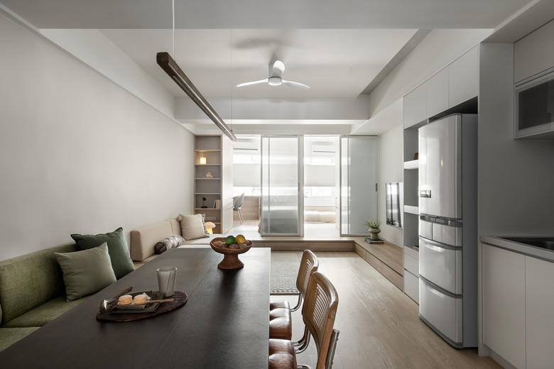 從餐廳看老屋改造後室內,光線透過玻璃門流淌